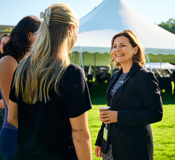 La présidente Katia Passerini se tient devant des fenêtres dans le centre Hemmingson